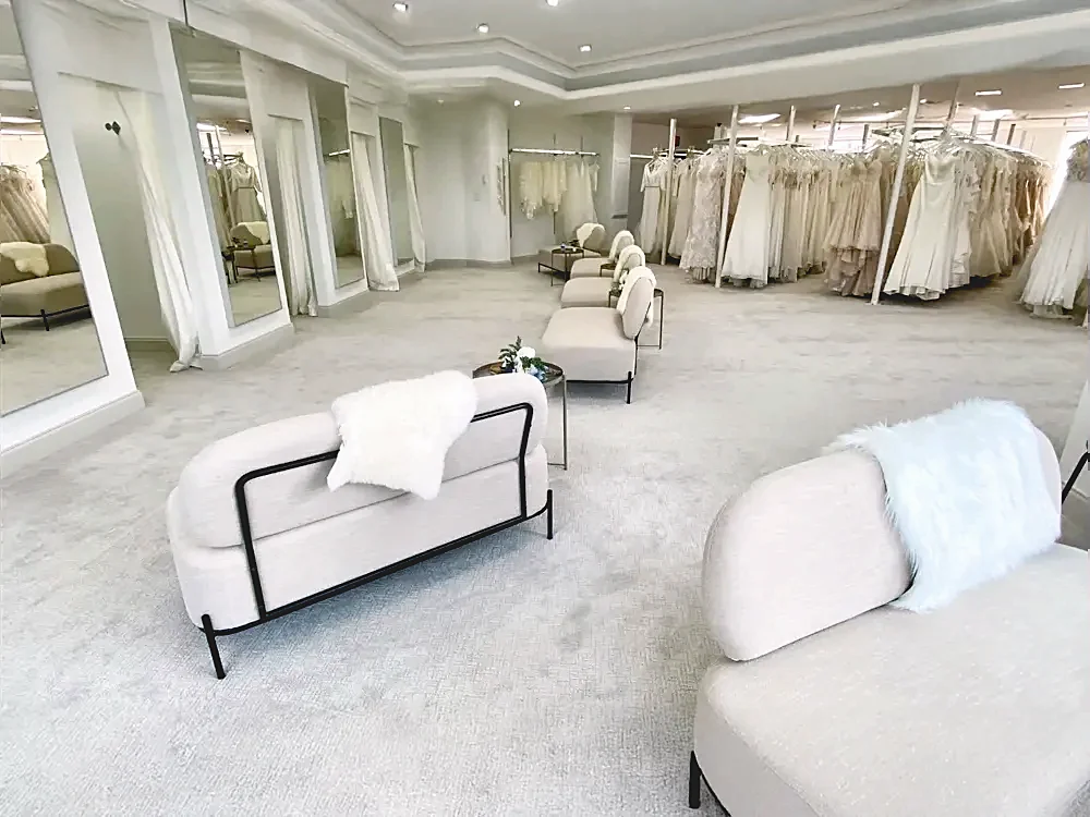 Bright bridal showroom with gown racks and lounge seating at Last Look Bridal Outlet